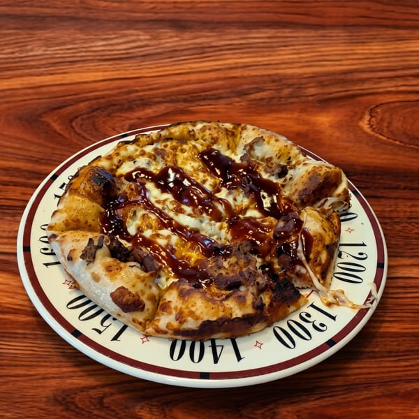 A delicious pizza with melted cheese and barbecue sauce on a white plate with numbers.